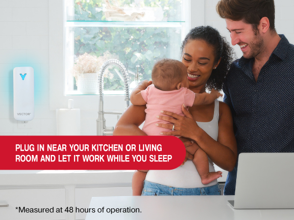 Family smiles in a bright kitchen with baby while Vector plug-in trap works near the sink overnight.