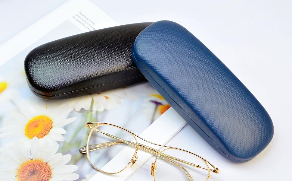 Two hard eyeglass cases, one black and one blue, with textured surfaces. A pair of gold-framed glasses rests in front, on a floral background.