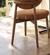 Wooden chair with curved back and four legs, mid-century modern style design, light natural wood finish, minimal upholstery.
