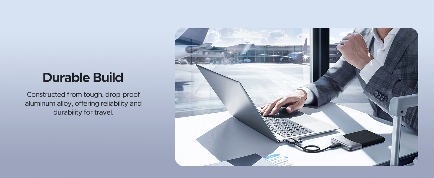 Laptop on a desk with a person typing, showcasing durable build. Text mentions 'Durable Build' and describes aluminum alloy construction for longevity and durability.