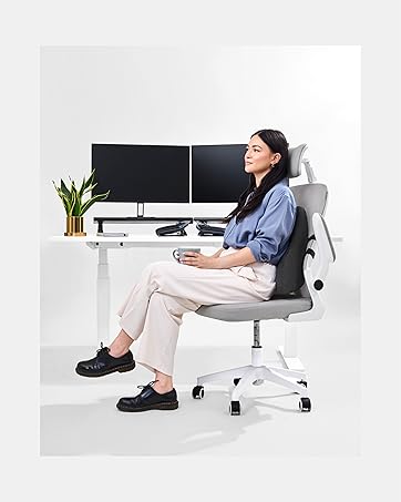 Professional office woman sitting upright on office chair leaning against lumbar pillow