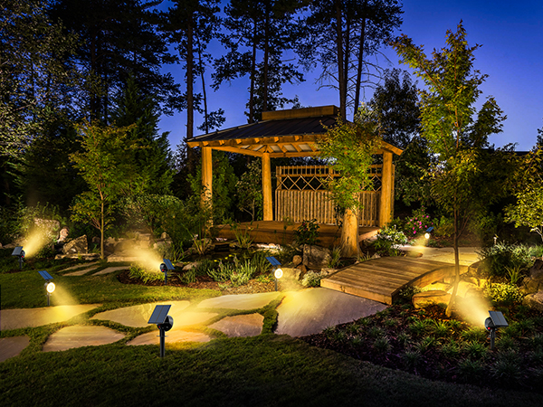 a gazebo in a garden with a walkway and a walkway.