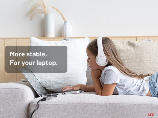 a young girl laying on a couch with headphones on her head.
