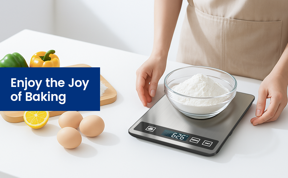 Digital kitchen scale with glass bowl of flour on top. Nearby are eggs, lemon, and bell peppers. Text reads 'Enjoy the Joy of Baking'. Scale display shows 636 grams.