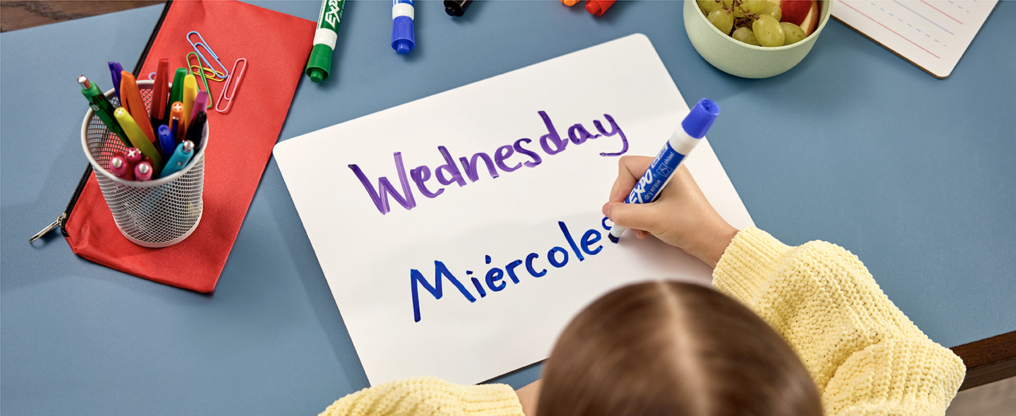 Girl writing with market on white board