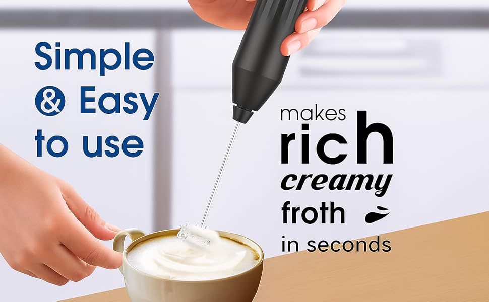 Image showing a person using a handheld black electric milk frother to foam milk in a beige cup