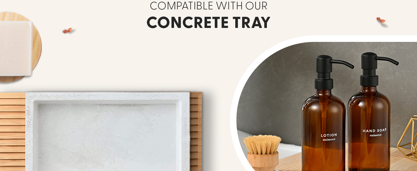 Text reads 'COMPATIBLE WITH OUR CONCRETE TRAY'. Product display showing beige/cream colored cylindrical container, white rectangular tray, wooden slats, and two amber glass pump bottles with black tops on dark surface.