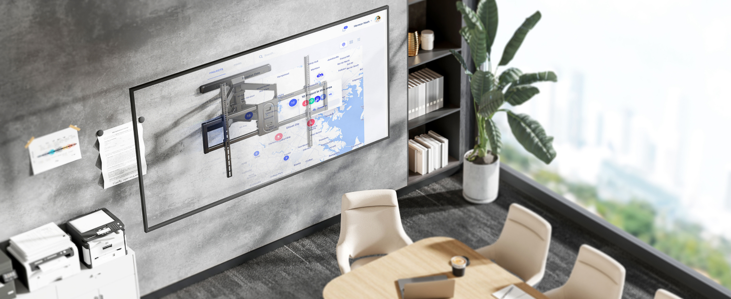 Modern home office or workspace with large wall-mounted display, floating shelves, potted plant, and contemporary seating area.
