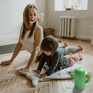 In the mist of the humidifier, a mother with her daughter is doing yoga