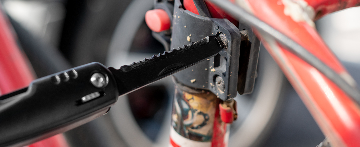 Close-up of black metal bicycle brake mechanism with red frame components visible.