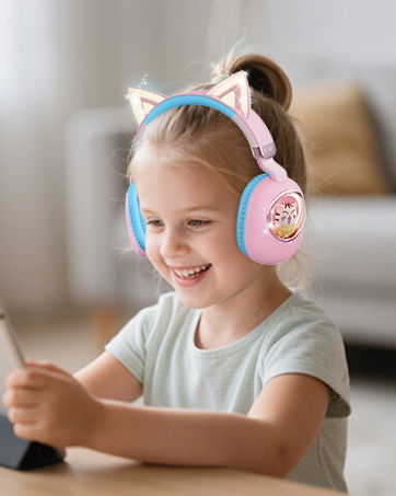 Someone wearing white headphones while sitting at a desk in a bright, sunlit room. Focus on the white headphones with soft blue accents.