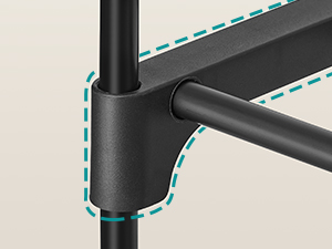 Close-up of a black metal joint connecting two tubular components. The joint features a smooth, matte finish and appears to be part of a larger structure.
