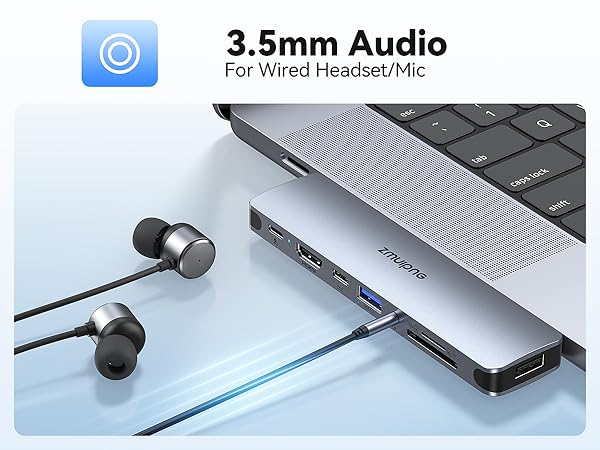 3.5mm audio port on a laptop docking station with wired earbuds plugged in. Text overlay: '3.5mm Audio For Wired Headset/Mic'.