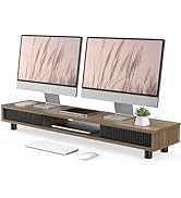 Wooden monitor stand with ribbed ventilation panels, supporting two desktop monitors. Features built-in storage space and modern design.