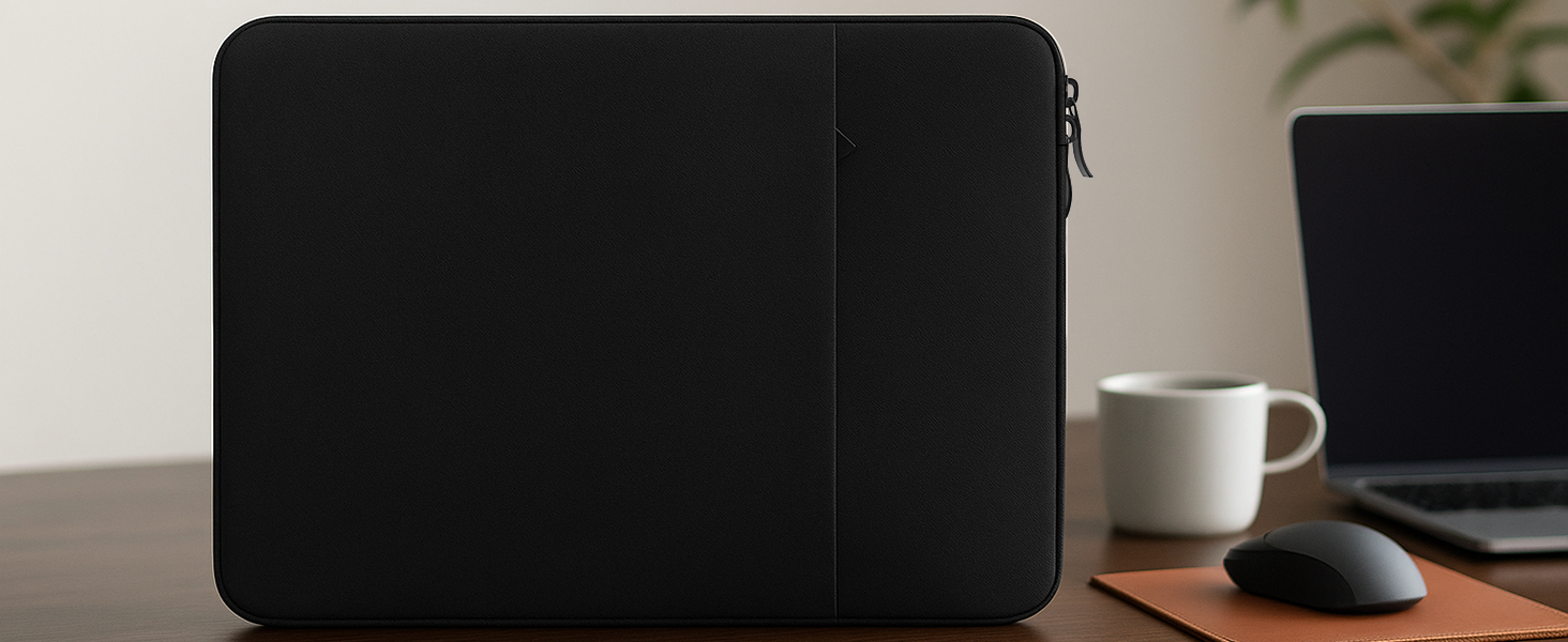 Modern black soundbar mounted on wall beneath TV, with minimalist design and clean lines. Small white cup visible on desk surface.