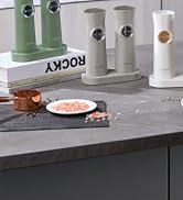 Set of cylindrical kitchen containers in green, gray, and white colors. Each has a circular opening on the side. Displayed on a dark countertop with food ingredients.