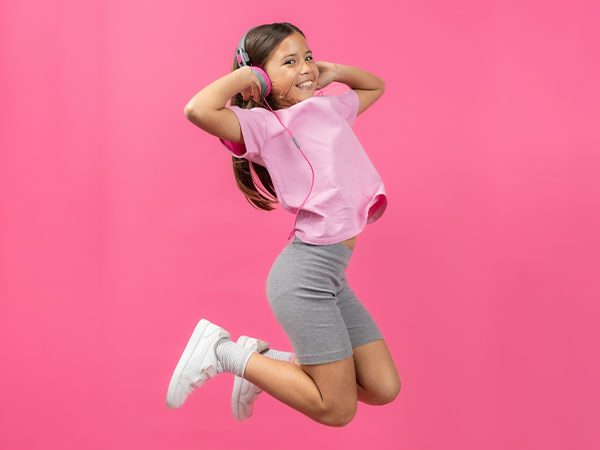 Girl wearing JBuddies studio 2 wired jumping into the air
