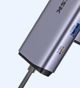 Silver rectangular device with USB ports visible, likely a USB hub or docking station, shown against a white background.