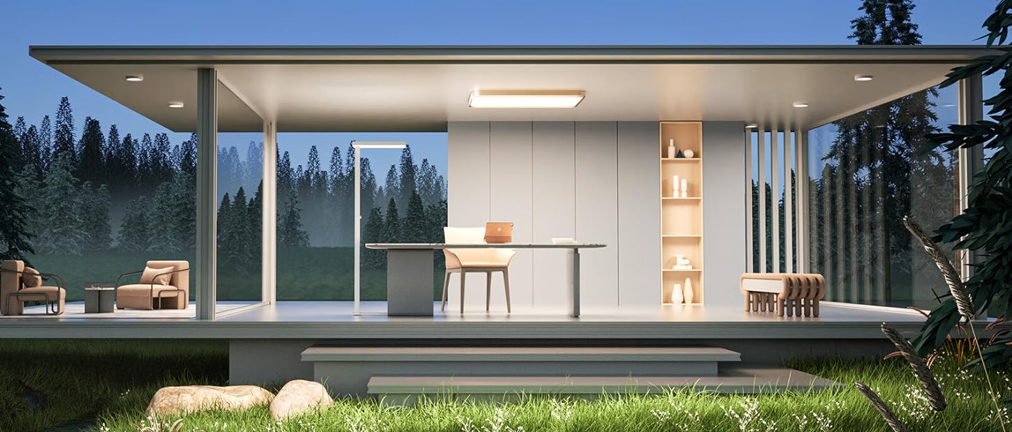 Modern, glass-walled prefab structure in a forest setting at dusk. Interior lighting illuminates minimalist furnishings and open-plan design.