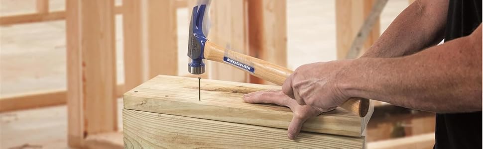 Power tool drilling or screwing into wooden plank or board on workbench surface.