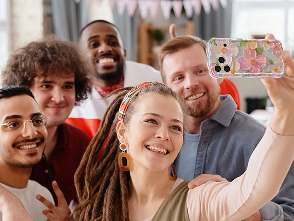 Group of people in casual setting holding up mobile phones while smiling, appearing engaged in a shared activity.