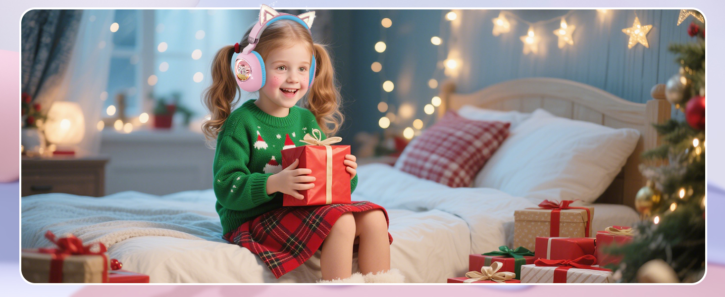 Holiday scene showing decorated bedroom with string lights and stars. Child in green and red plaid outfit seated on bed holding red gift package.