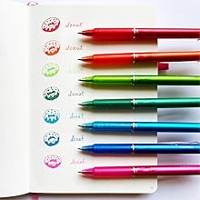 Photo shows rainbow of colored FriXion Clicker pens next to colored flowers drawn by each pen