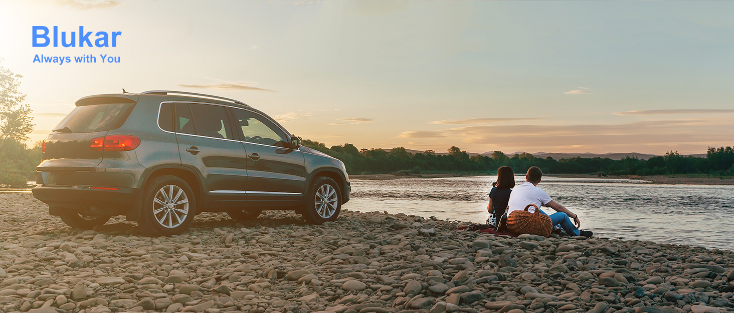 a woman sitting on a beach next to a lake.