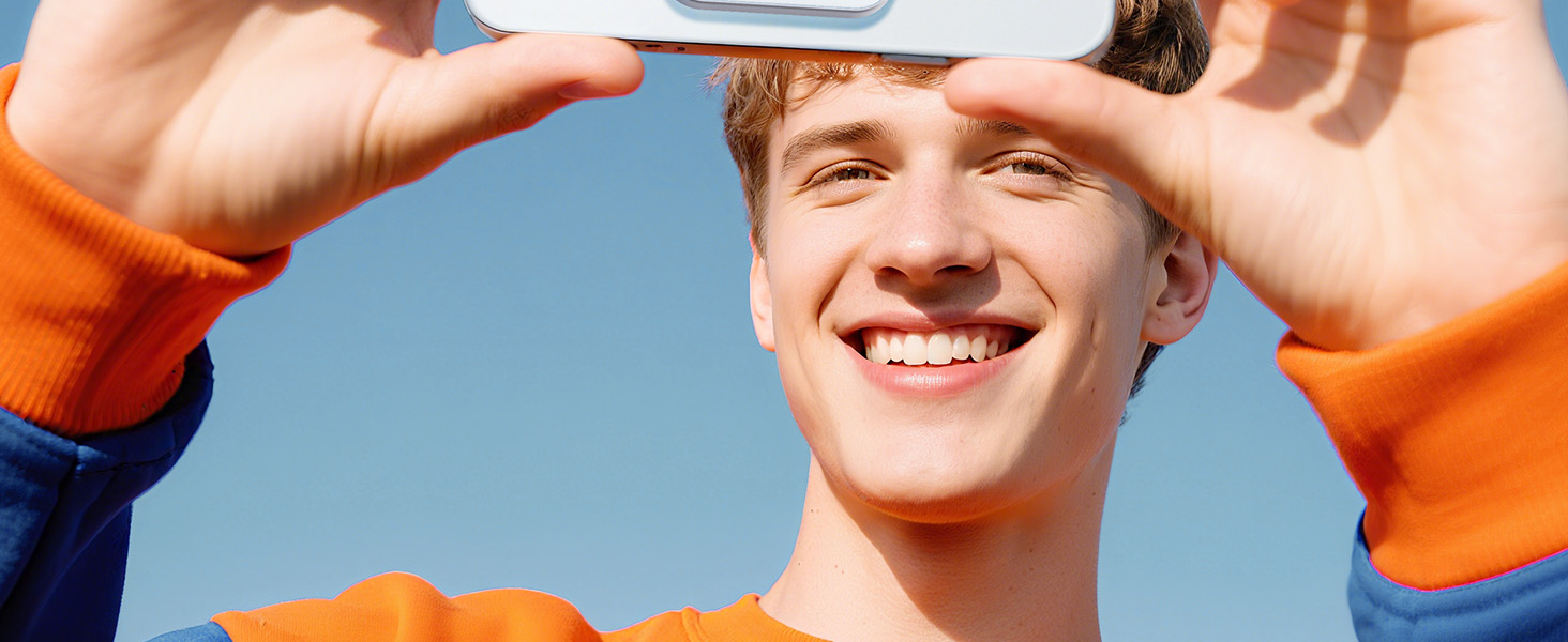 Person in orange shirt shielding eyes while looking upward against blue sky background.