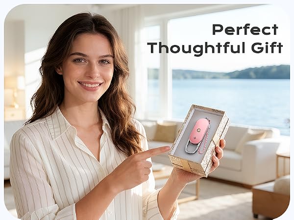 Text reads 'Perfect Thoughtful Gift'. Woman holding smartphone displaying pink design, standing indoors with coastal window view.