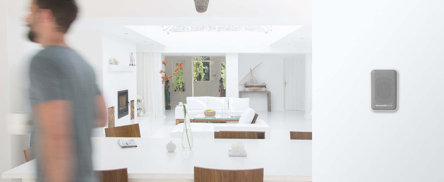 RDWL313P plugged into wall outlet with modern white living room in background and man walking past.