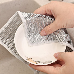 Hands demonstrating a mesh laundry bag for delicates. One hand holds the bag open while the other places a white garment inside.
