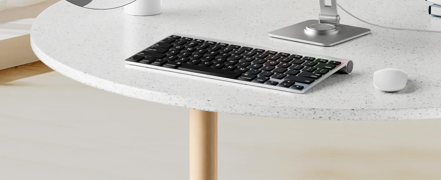 Modern workspace setting with wooden desk surface, partial view of keyboard, mouse, and cylindrical wooden table or desk leg visible.