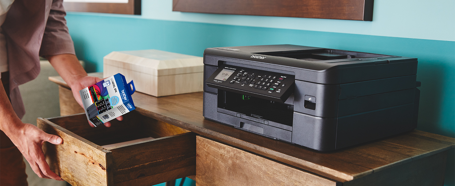 Person picking up LC401 ink cartridges from desk drawer