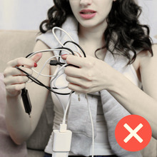 This image shows a displeased woman holding tangled regular charging cables