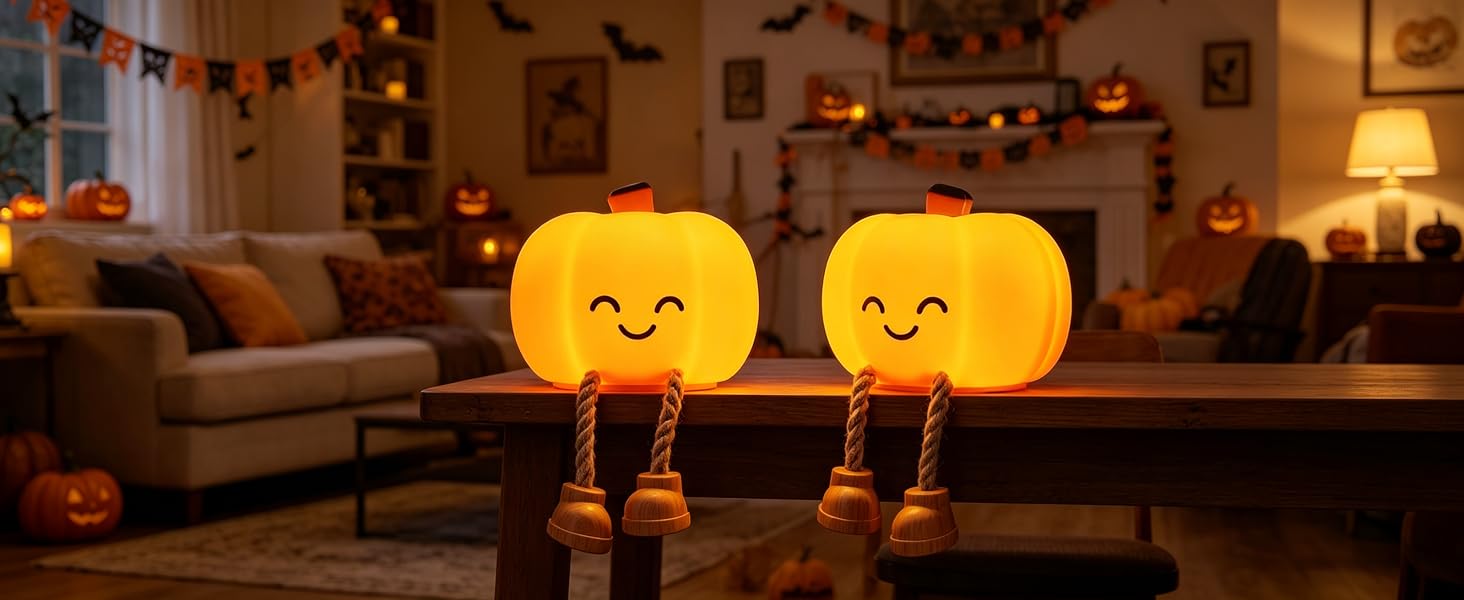 Two pumpkin night lights are placed on the table