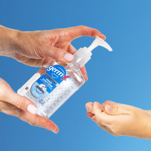 GermX Hand Santizer on Hands Blue Background