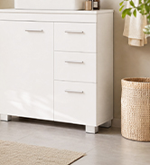 White cylindrical storage container or dispenser displayed on wooden shelf next to cream-colored toiletries and home decor items in minimalist bathroom or bedroom setting.