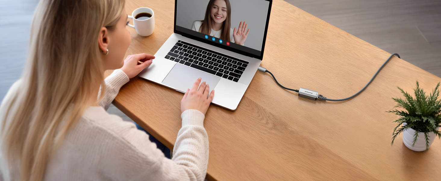 A Woman Having Video Calls on a Laptop with the USB-C to 2.5G Ethernet Adapter Connected