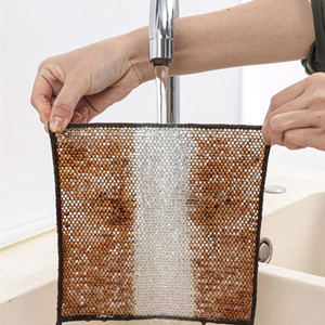 Hands holding a square mesh filter under running water. The filter has brown stains being rinsed away, revealing clean silver mesh underneath.