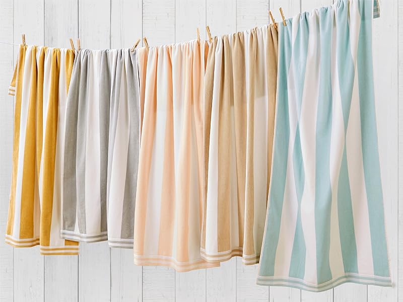 hanging cabana striped towels in a variety of colors on a white shiplap wall