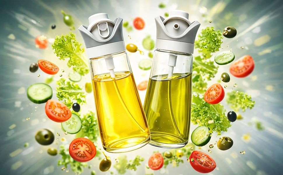 Two oil bottles with spray tops float amid salad ingredients like lettuce, tomatoes and cucumbers.