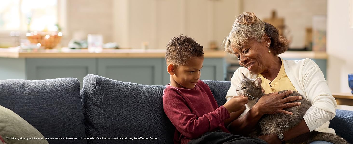 A grandma and grandson petting a cat, Kidde low level carbon monoxide alarms protection, desktop