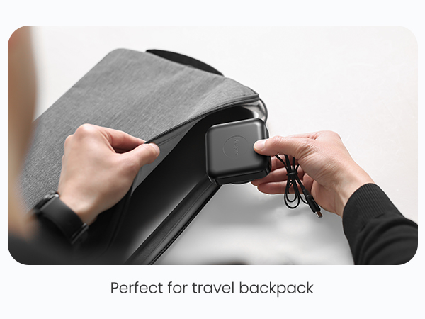Hands opening a gray travel backpack, revealing a hidden pocket containing a small black electronic device with attached cord. Text indicates suitability for travel.