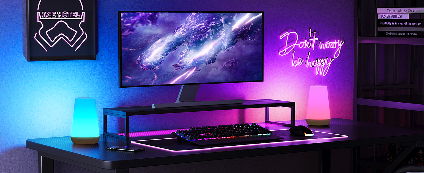 Gaming setup featuring curved monitor, RGB keyboard, neon sign, and ambient lighting with purple and blue hues on a dark desk.