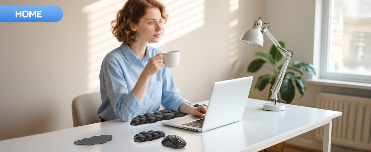 Home office setup with white desk, laptop, desk lamp, and houseplant. Multiple computer mice on desk. Person holding coffee mug while working.