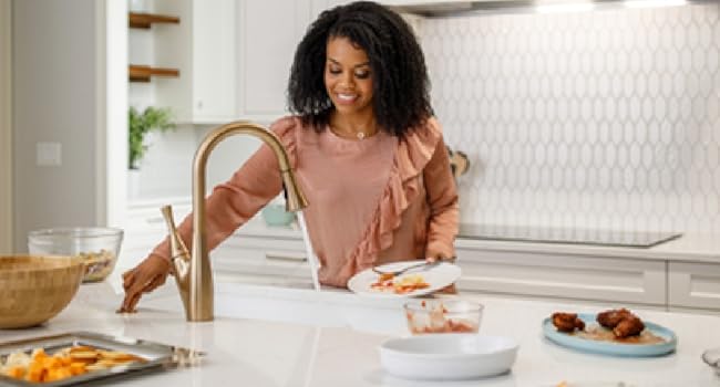 Woman by sink using garbage disposer
