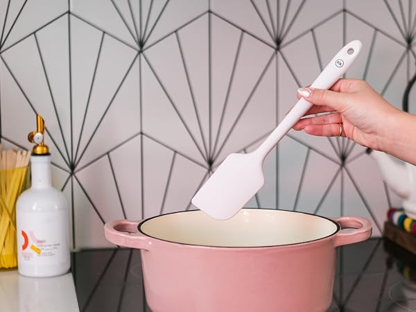 Silicone spatula using to cook in a pink pot on the stovetop
