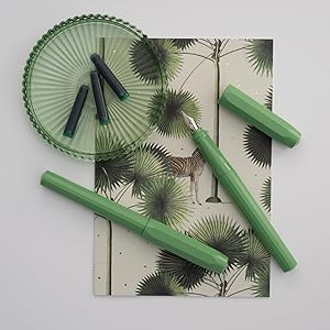 a green pen and a green pen on a notebook.
