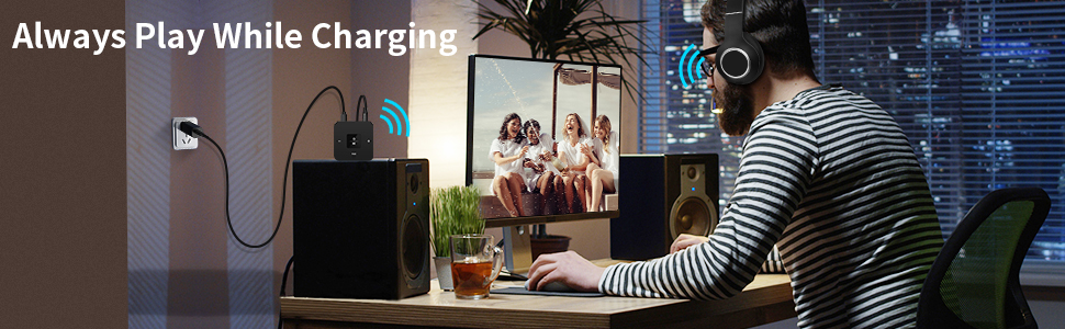 a person is sitting at a desk with a laptop and a picture of a family on the screen.